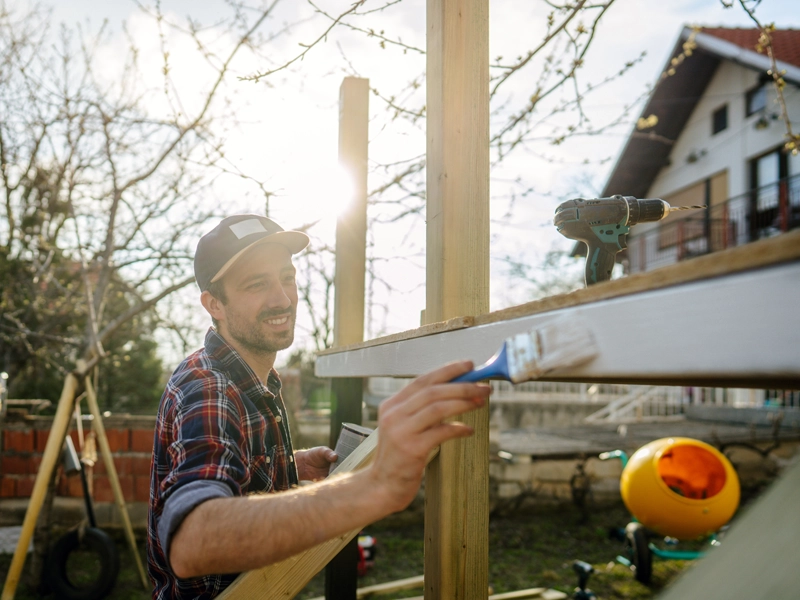 man painting his home