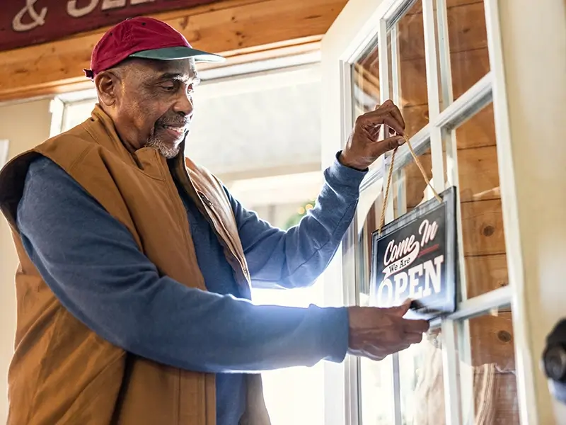 elderly man opening store